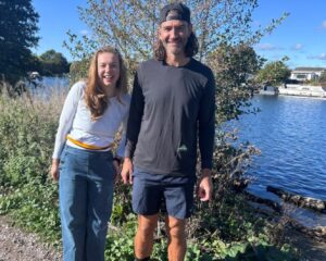 Charlotte and Tommy stand on the bank